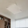 A white fabric ceiling light fixture is suspended from a concrete ceiling in a room with a wooden bookshelf and a window with blinds. Produktbild-Vorschau