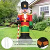 An inflatable nutcracker soldier decoration stands in a grassy yard in front of a house. Produktbild-Vorschau