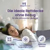 A woman sleeping peacefully on a bed with a duvet. Produktbild-Vorschau