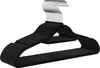 A stack of black velvet hangers with silver hooks.