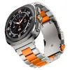 A close-up, angled view of a smartwatch with a metal band and orange accents. Náhled obrázku produktu