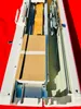 A top-down view of a knitting machine with cardboard packaging inside. Produktbild-Vorschau