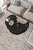 A modern living room with a couch and a unique yin-yang shaped coffee table. Produktbild-Vorschau