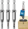 A set of three metal drill bits with a tag attached to one of them, shown against a white background. Another drill bit is shown in use on a piece of wood. Náhled obrázku produktu