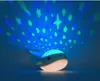 A whale-shaped night light projecting stars onto a blue background. Produktbild-Vorschau