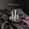 A table setting with lit candles, pinecones, and cookies, suggesting a cozy, festive atmosphere. Produktbild-Vorschau