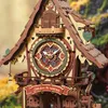 A detailed close-up of a wooden 3D puzzle cuckoo clock, with intricate gears and decorative elements. Náhľad obrázku produktu