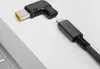 A close-up shot of a USB-C adapter and a USB-C cable on a white background, with a portion of a laptop visible in the foreground. Náhled obrázku produktu