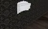 A white wall-mounted shelf with three drawers and two hooks is shown against a dark, patterned wallpaper and a wooden floor. Náhled obrázku produktu