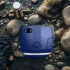 A blue mini-refrigerator is placed on a rocky surface near a body of water, with a metal water bottle next to it. Náhled obrázku produktu