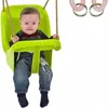 A baby sitting in a green swing. Podgląd zdjęcia produktu