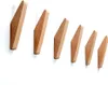 A set of six wooden wall hooks of increasing size mounted on a white wall. Produktbild-Vorschau