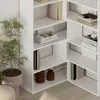 A white corner bookshelf unit with books and decorative items. Produktbild-Vorschau