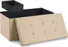 A beige storage ottoman with its lid open, revealing a black interior and a black insert box on top. The lid is tufted with buttons. Produktbild-Vorschau