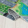 A close-up view of a rolled-up children's play mat depicting a road and park scene. Produktbild-Vorschau