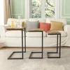 Three C-shaped side tables are placed in front of a white sofa with colorful throw pillows. Voir les images du produit