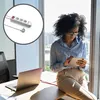 A woman is using a tablet while sitting on a desk next to a laptop, with a power strip visible in a circular inset. Produktbild-Vorschau