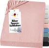 A pink fitted sheet is folded and displayed with a product tag attached.