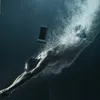 A man diving underwater with a waterproof phone case. Anteprima dell’immagine prodotto