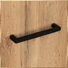 A black handle is mounted on a wooden surface. Podgląd zdjęcia produktu