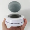 A hand holds a white smoke detector with a black disc on top, with a gray disc floating above it. Produktbild-Vorschau