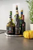 Several bottles of oil and a small pumpkin are arranged on a kitchen counter. Anteprima dell’immagine prodotto