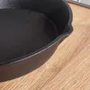 A close-up view of a black cast iron frying pan resting on a wooden surface. Produktbild-Vorschau