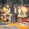 Christmas decorations hanging in a window with snow falling outside. Produktbild-Vorschau