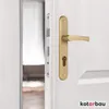 A close-up of a gold door handle and lock mechanism on a white door. Produktbild-Vorschau