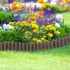 A garden border made of brown wooden-look palisades separates a lawn from a flower bed filled with various colorful flowers and green foliage. Náhled obrázku produktu