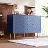 A blue sideboard with a scale pattern and gold legs is placed in a room with wooden walls and a large window. Anteprima dell’immagine prodotto