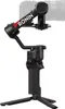 A black camera gimbal stabilizer with a tripod base, shown from a side-diagonal angle against a white background. Náhled obrázku produktu
