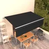 A balcony with a table, chairs, and a grill under a black awning. Produktbild-Vorschau