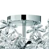 A close-up view of a chrome and acrylic glass ceiling lamp with floral accents. Náhled obrázku produktu