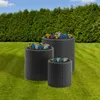 Three KETER planters of different sizes are arranged on a green lawn in front of a dense green hedge, under a blue sky with some clouds. Produktbild-Vorschau