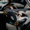A child is secured in a car seat in the back seat of a car. Produktbild-Vorschau