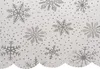 A close-up view of a white tablecloth with a repeating pattern of silver snowflakes and small dots. Podgląd zdjęcia produktu