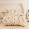 A neatly made bed with a duvet cover and pillows featuring a fruit and leaf pattern. Anteprima dell’immagine prodotto