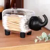 A clear plastic cotton swab holder shaped like an elephant sits on a wooden surface. Náhľad obrázku produktu