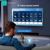 A person is sitting on a couch holding a remote and looking at a large TV screen displaying a weather forecast. Voice control is highlighted. Produktbild-Vorschau