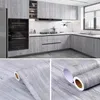 A modern kitchen with gray wood-effect cabinets and a close-up of the wood-effect vinyl wrap. Náhľad obrázku produktu