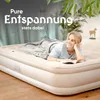 A woman is lying on an inflatable mattress, reading a book. Produktbild-Vorschau