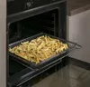 French fries being air-fried in an oven. Voir les images du produit