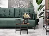 A living room scene featuring a green sofa, a side table with a vase and dried flowers, and a large plant. Podgląd zdjęcia produktu