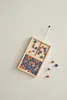 A wooden game with colorful beads on a light gray background. Produktbild-Vorschau