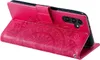 A pink flip case for a Samsung Galaxy A34 5G phone, with a mandala pattern embossed on the front cover. The phone is partially inserted into the case, showing the camera module. Produktbild-Vorschau