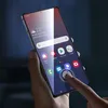 A hand holding a smartphone with a screen protector applied. Voir les images du produit