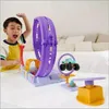 A young boy is excitedly playing with a toy car stunt set. Voir les images du produit