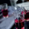 Several glasses filled with a red liquid are arranged on a table. Náhled obrázku produktu