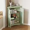A green corner cabinet with its doors open, displaying books and decorative items on its shelves. Produktbild-Vorschau